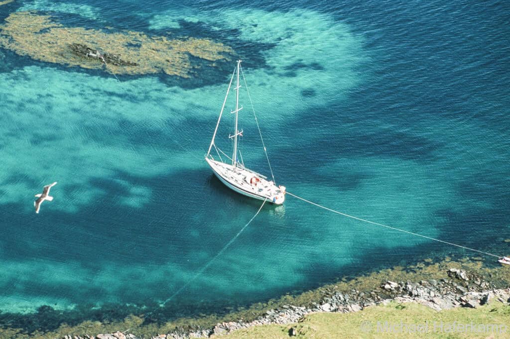 A sailing yacht anchored and using shore two shorelinesNote the two shorefasts off the stern and the bowline tied to a fortøyningsbolt on the skerry